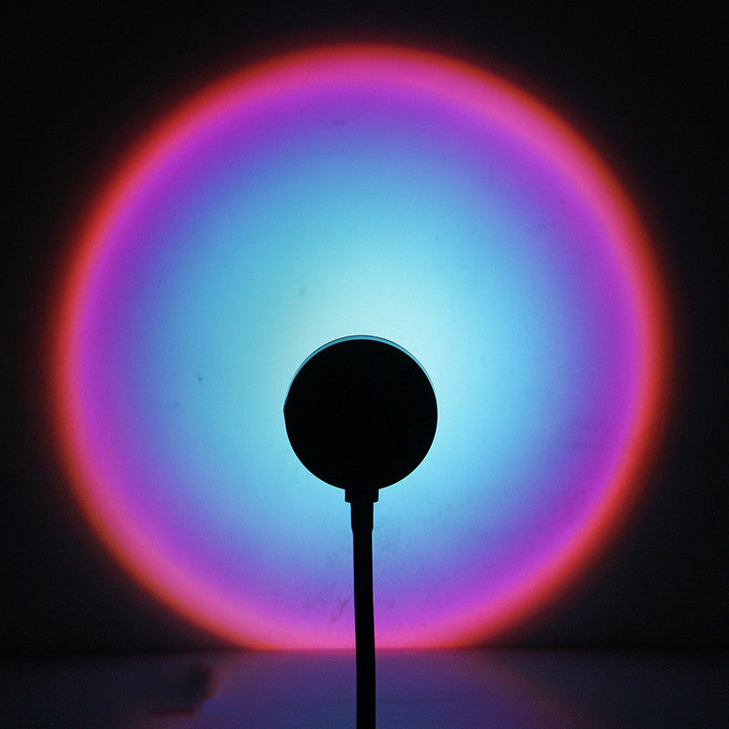 Sunset lamp projector casting a rainbow halo of light on the wall