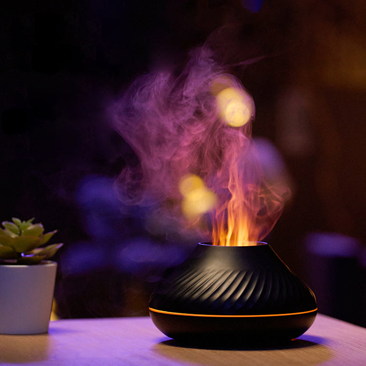 Flame diffuser with purple and orange mist in a dark room