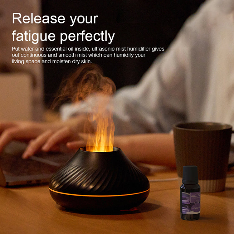 Flame diffuser on a desk with an essential oil bottle and a cup of coffee